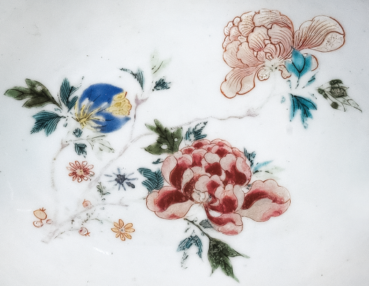圖為清中期粉彩花卉紋剃須盤細節(jié)圖，盤心主題紋飾為花卉圖。（來源：廣州十三行博物館）